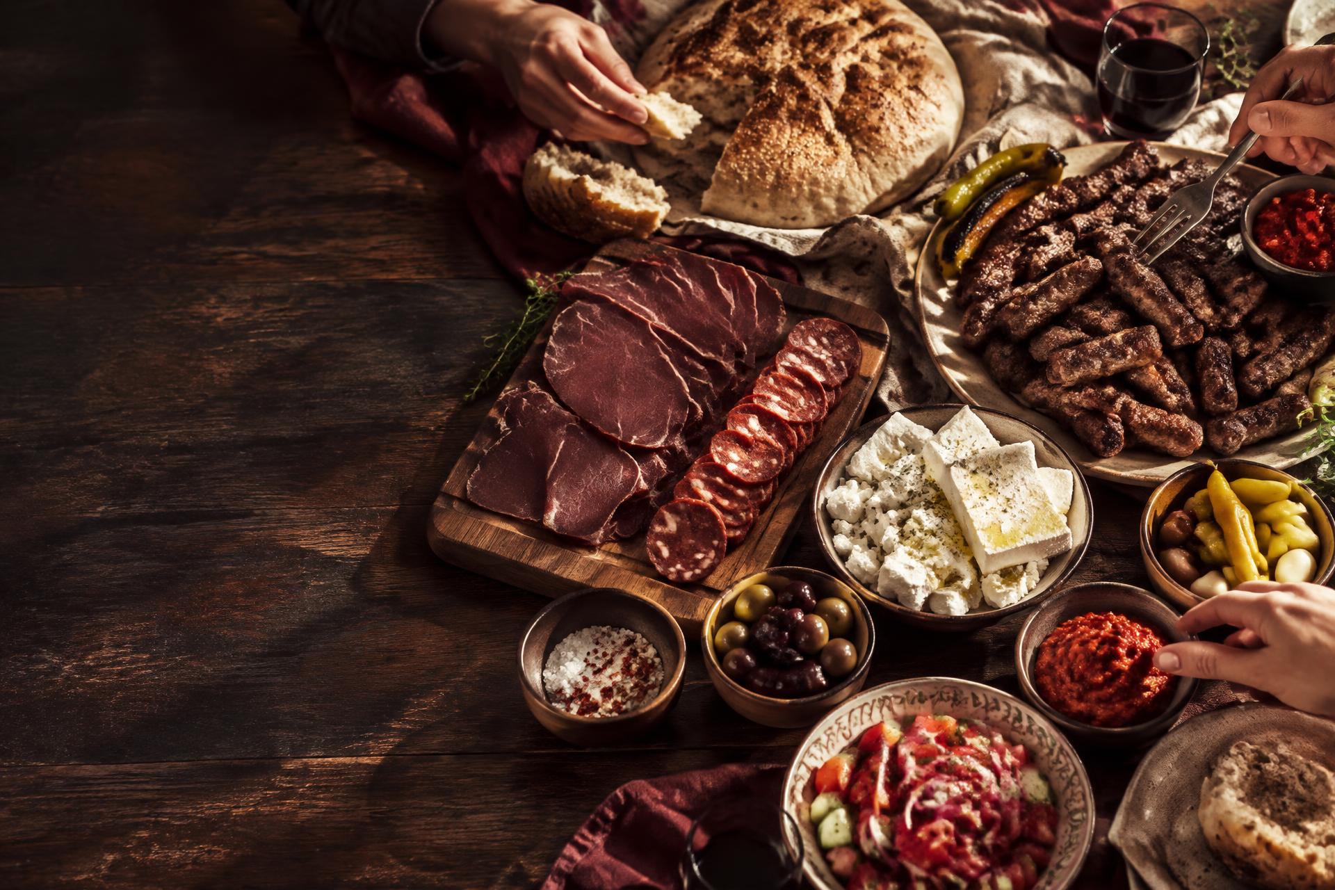 Große Balkan-Tafel mit Ćevapi, Somun, Ajvar, Käse und Fleischspezialitäten